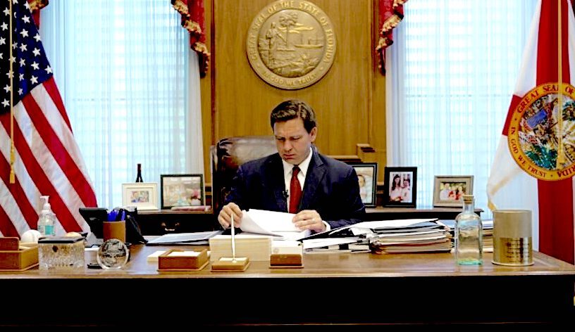 Click to enlarge Ron DeSantis at desk