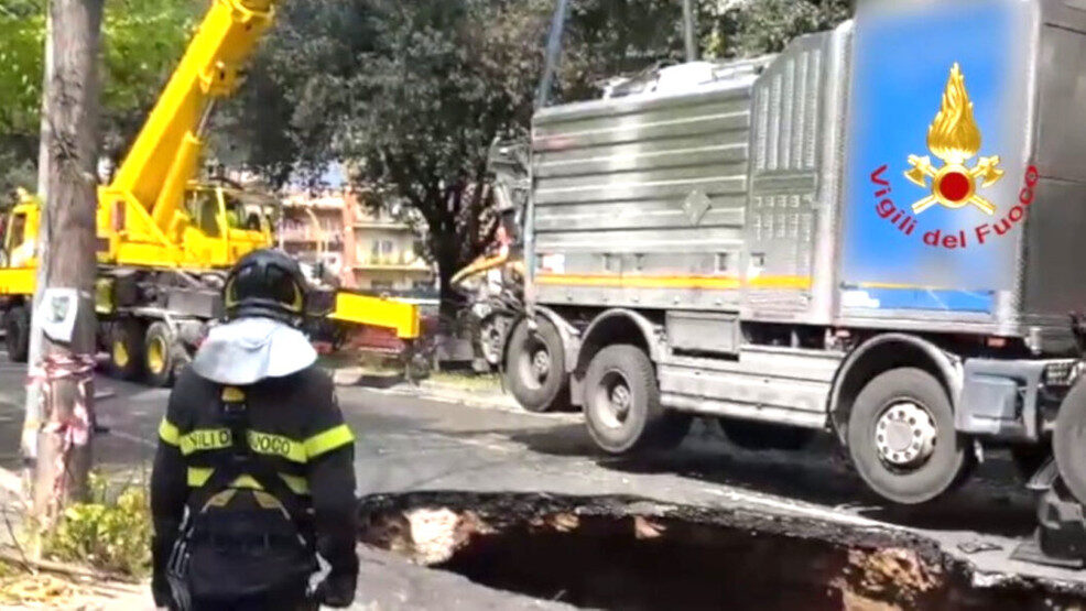 A truck is hauled from a hole 32 feet deep and 16 feet wide on Via dei Colli Portuensi in Rome.