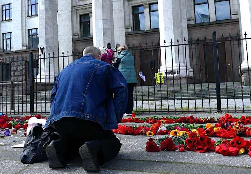 Click to enlarge Man laying flowers tribute