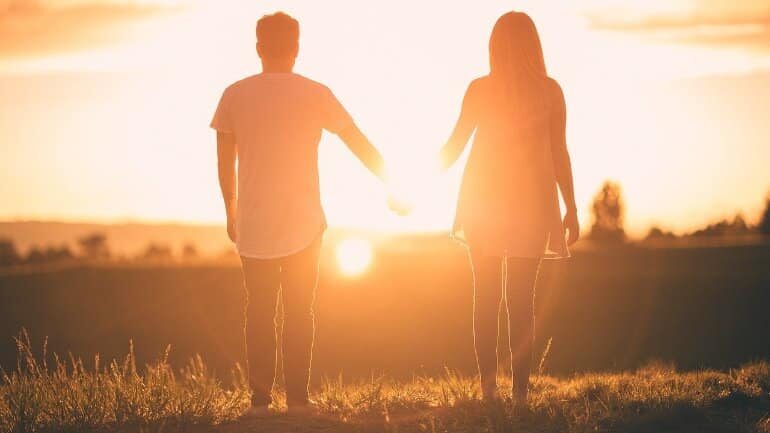 Couple holding hands in sunlight