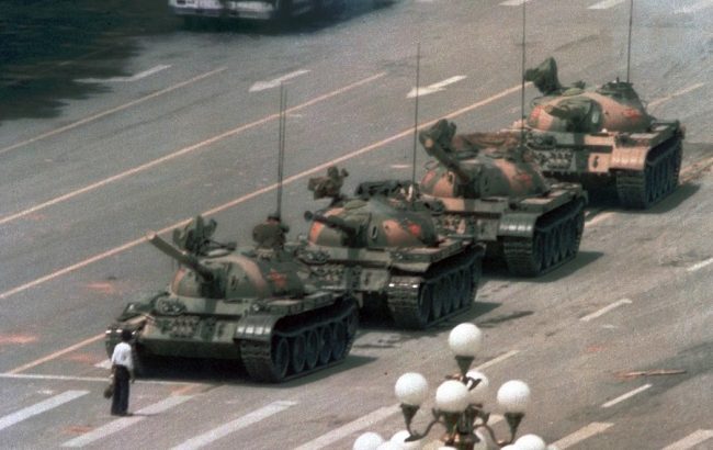 Child standing in front of tanks