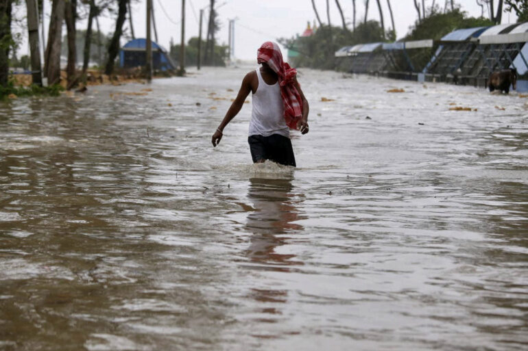 A man wades through a waterlogged road after rains ahead of Cyclone Yaas at Digha in Purba Medinipur district in the eastern state of West Bengal