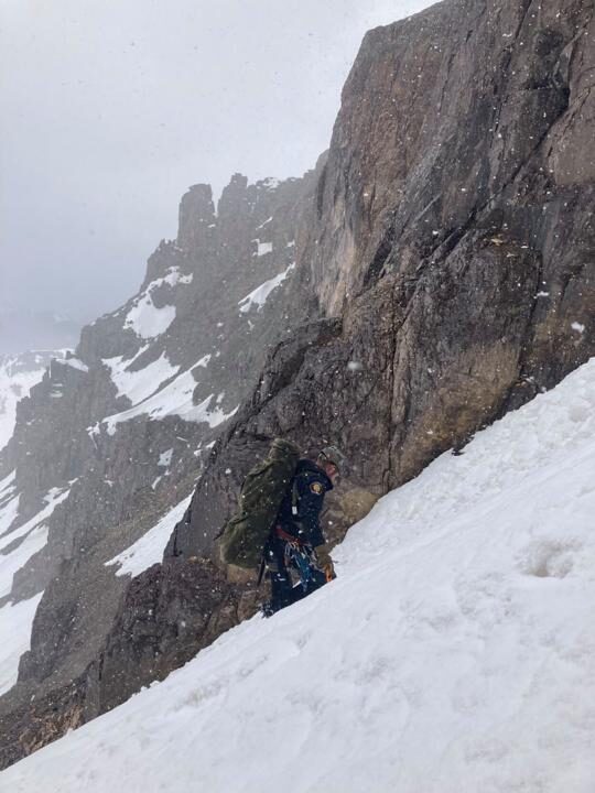 A crew member climbs up a steep snow-filled slope during the recovery operation.