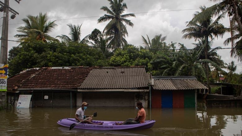 Click to enlarge A raft floats along a flooded street in Malwana, Sri Lanka on Saturday.