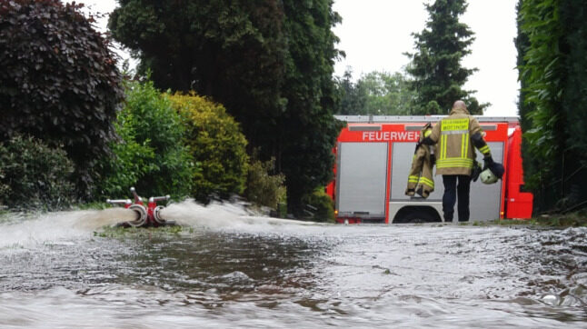 A fireman crosses a flooded street in Bottrop,