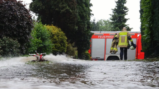 Click to enlarge A fireman crosses a flooded street in Bottrop,