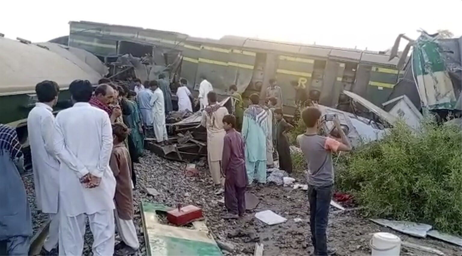 People gather at the site of the deadly train collision in Ghotki, Pakistan