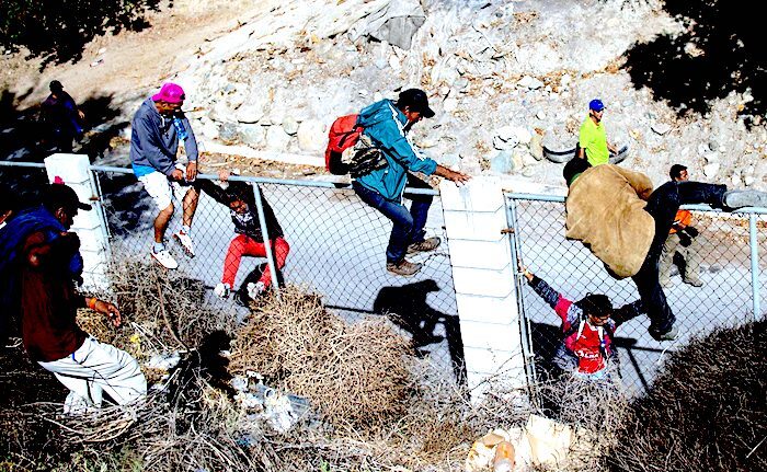Migrants over fence