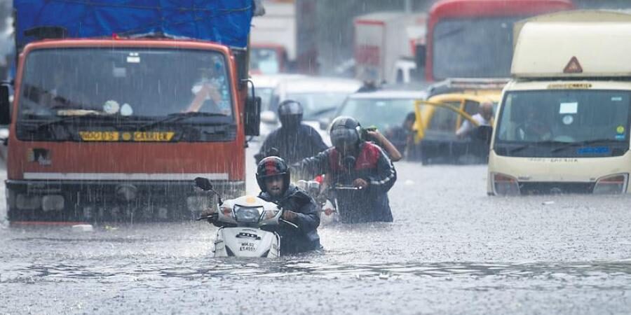 Click to enlarge Vehicles make their way through a waterlogged road during heavy rain, at Kings Circle, in Mumbai.