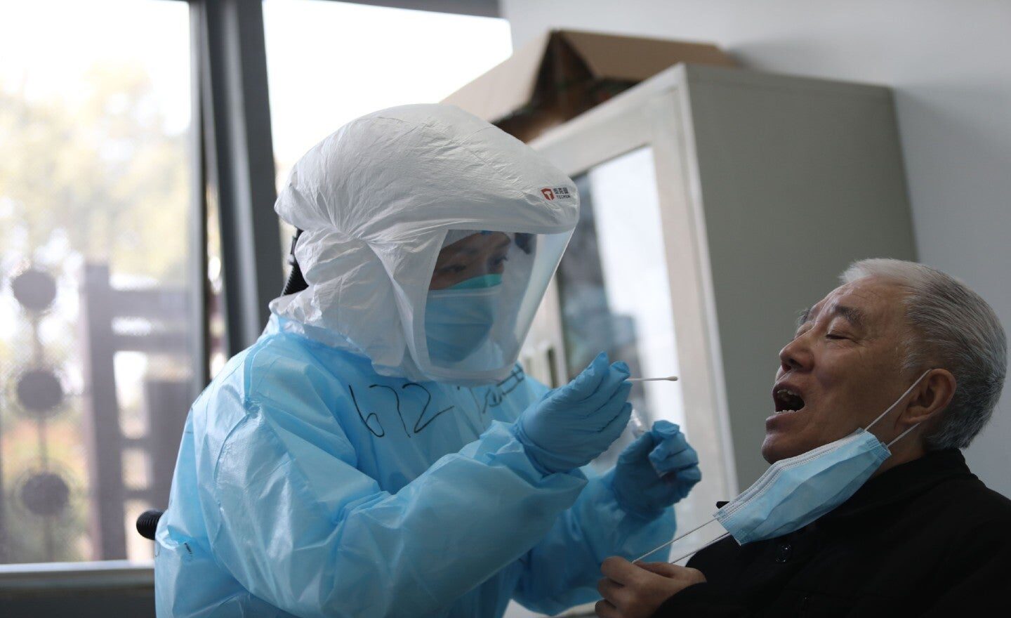 Click to enlarge Chinese scientist swabs patient