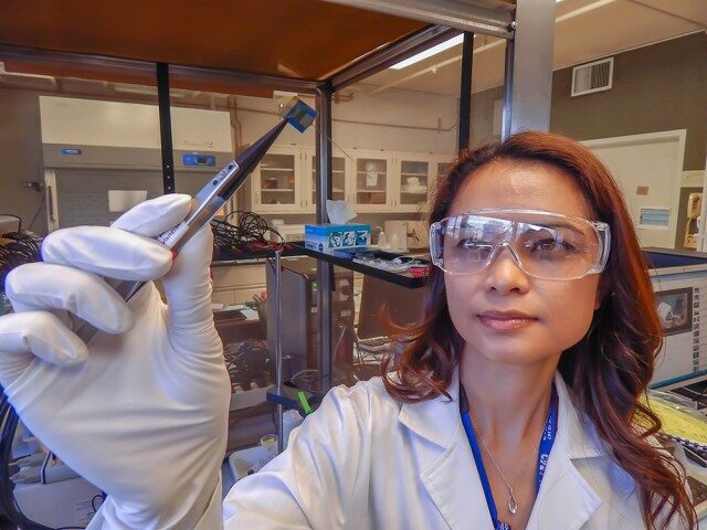 Click to enlarge engineer Vanessa Tolosa holds up a brain implant