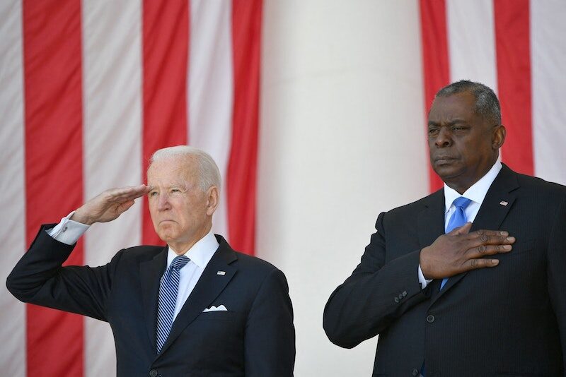US President Joe Biden salutes along with Secretary of Defense Lloyd Austin