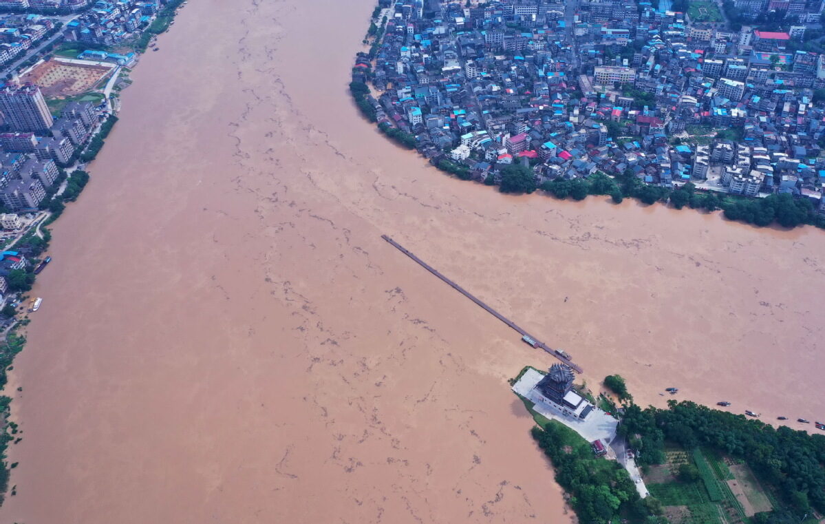 Click to enlarge Floodwaters almost submerge a ferry bridge in Rong'an county in Liuzhou, Guangxi Zhuang autonomous region, on Friday.
