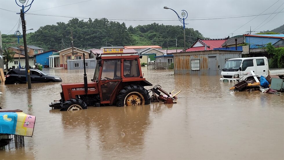 Click to enlarge A tractor and vehicles are stuck in a flooded street in Jindo County, South Jeolla Province, July 6.