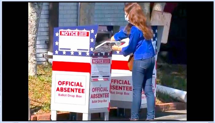 Click to enlarge woman collecting ballots