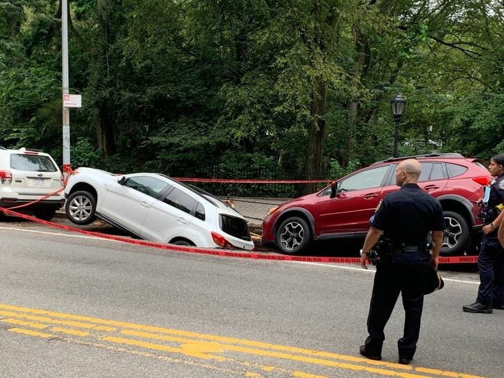 An image of two cars falling into a sinkhole