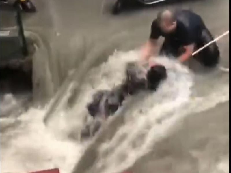 A woman has been pulled out of floodwaters in the Chinese city of Zhengzhou, which has been battered by heavy rain and flooding.