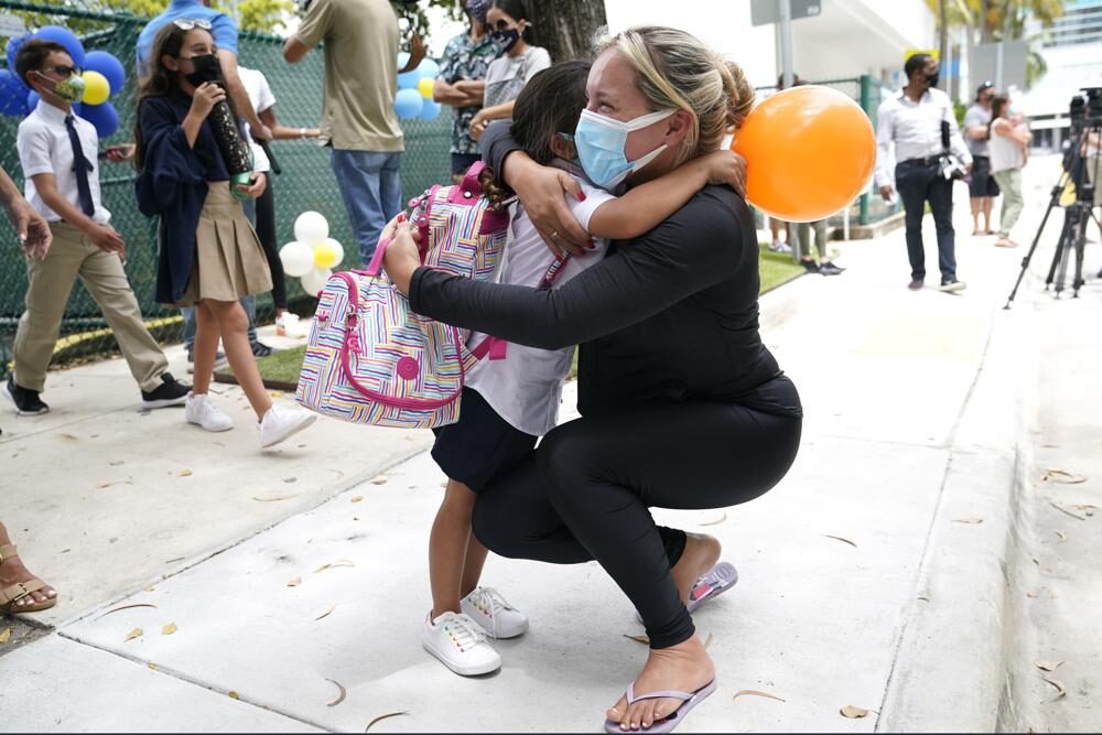 Carol Basilio, right, hugs her daughter Giovanna outside of iPrep Academy