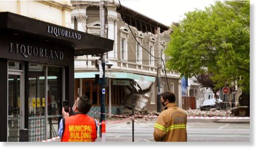 Emergency workers survey damage in Melbourne, Australia, where debris is scattered after part of a wall fell from a building