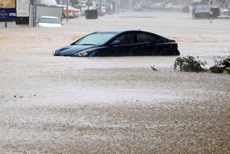 A car is partially submerged on a flooded street as Cyclone Shaheen makes landfall in Muscat Oman, October 3, 2021