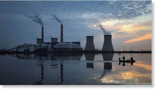 Fishermen sail a boat past a power plant of the State Development and Investment Corporation outside Tianjin, China on October 14.