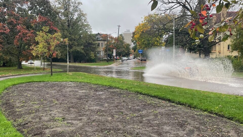 A driver creates a large splash while driving down a flooded street in Ottawa. Oct. 16, 2021.