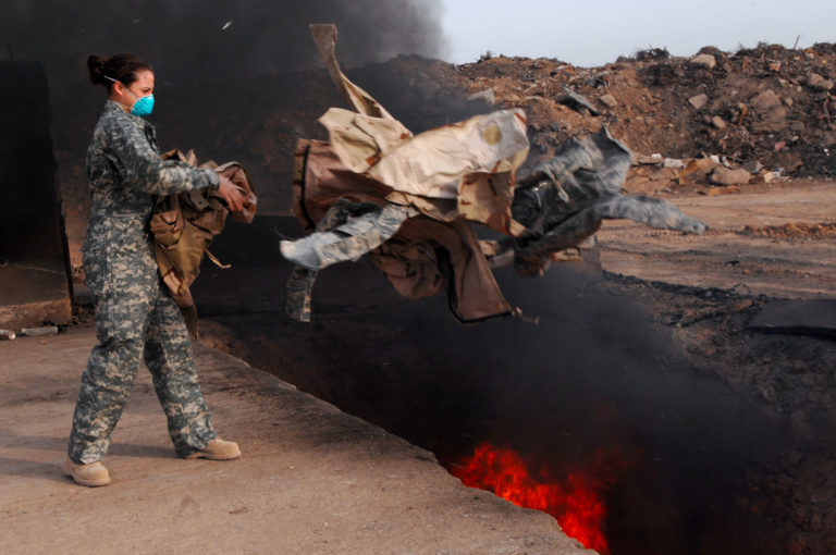 Burning used uniforms  into a burn pit at Balad Air Base