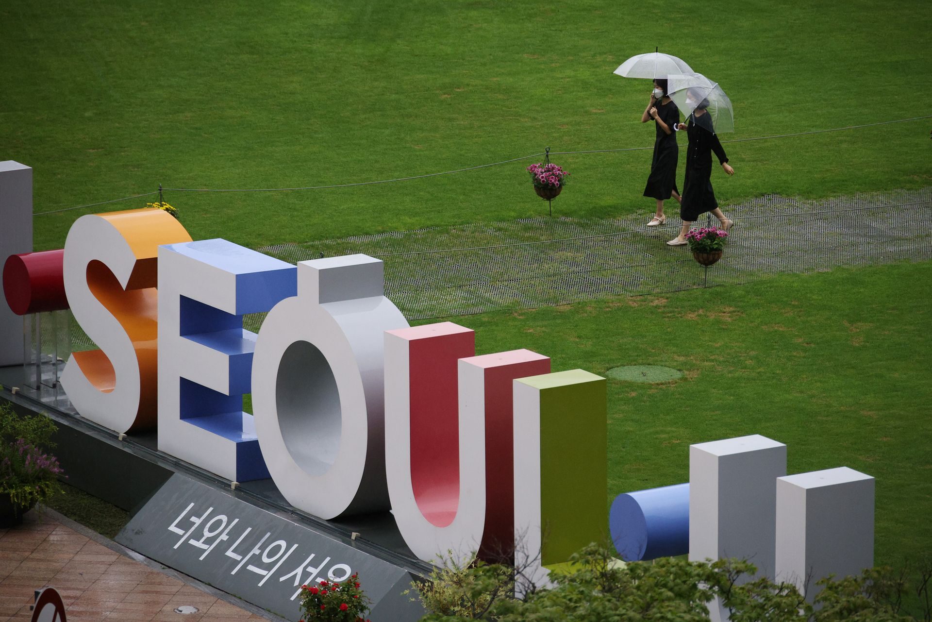 Click to enlarge Women wearing masks walk at a park in Seoul, South Korea