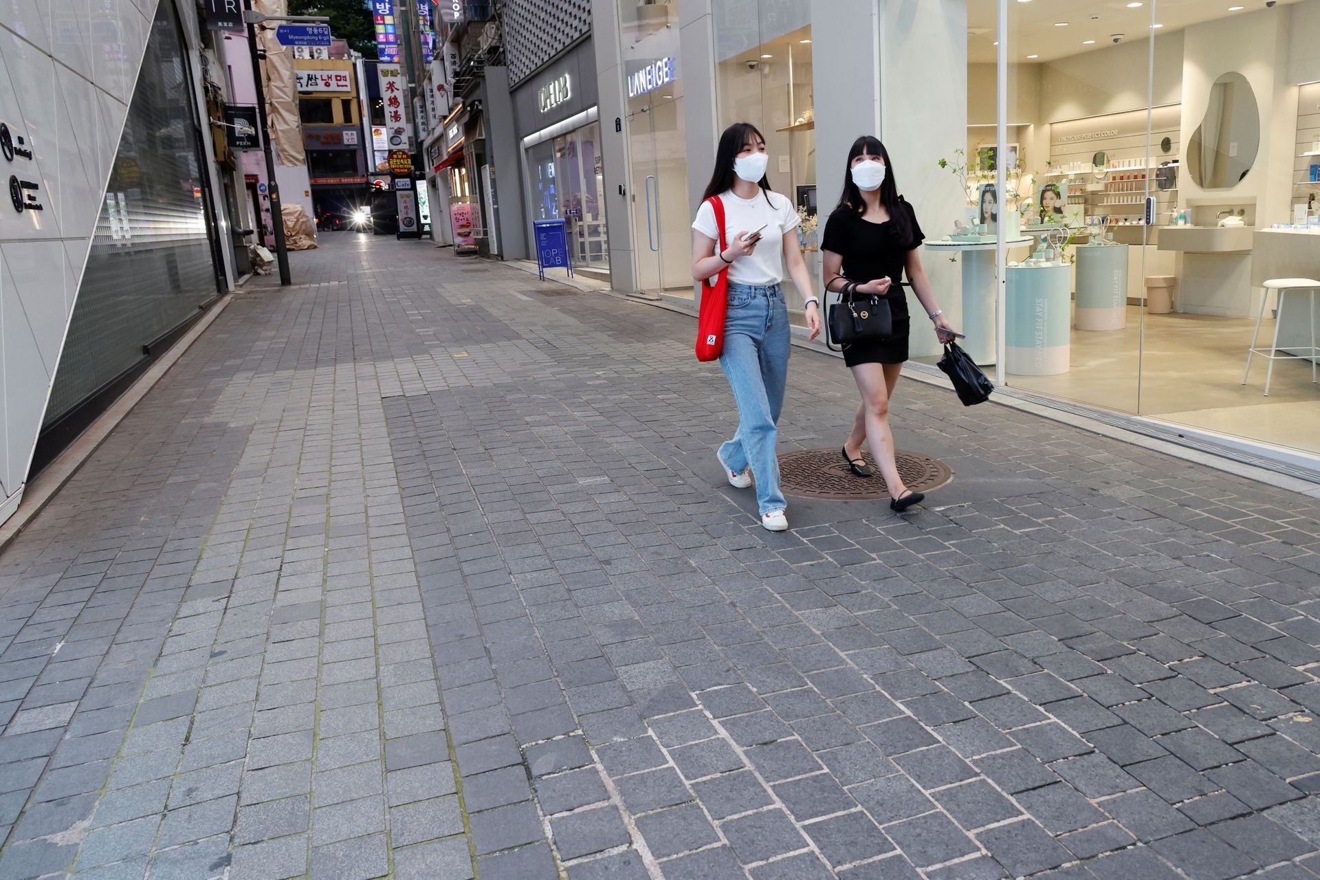 Women walk on an empty street  in Seoul, South Korea