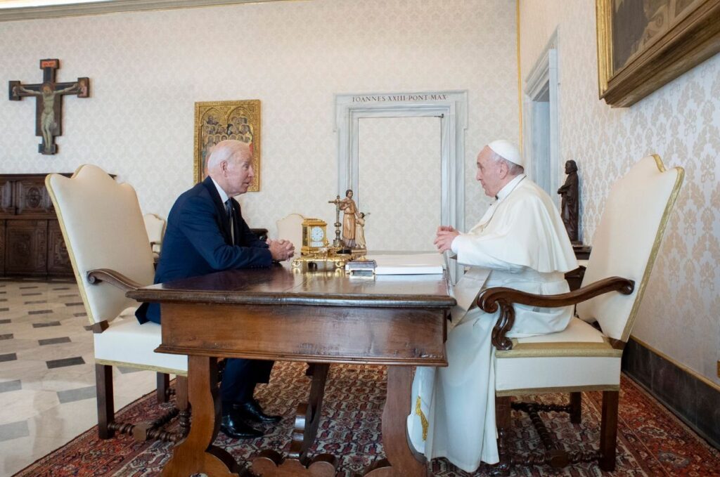 President Biden and the Pope sitting on white chairs at the Vatican