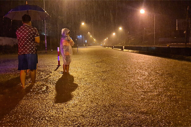 Click to enlarge Residents at Bang Klong Luek in Hat Yai district of Songkhla watch as continuous rain floods a main road in Muang district in the early hours of Friday.