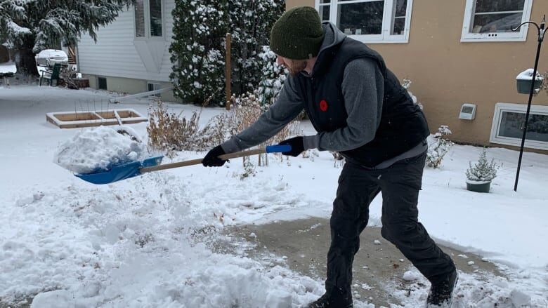 Mark Lavoie shovels snow in Saskatoon on Thursday. Saskatoon saw six to nine centimetres of snow over two days, Environment Canada says.