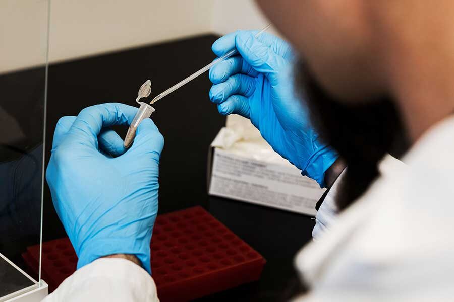 Matthew J. Jones takes a sample of dust collected from a chicken farm