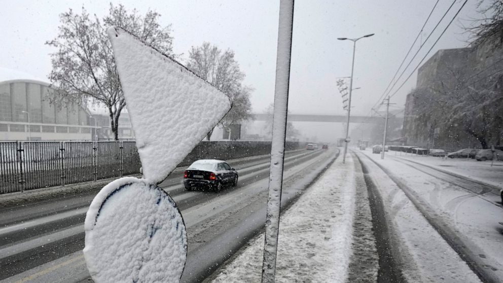 Cars on the street during snow storm in Belgrade, Serbia, Sunday, Dec. 12, 2021.