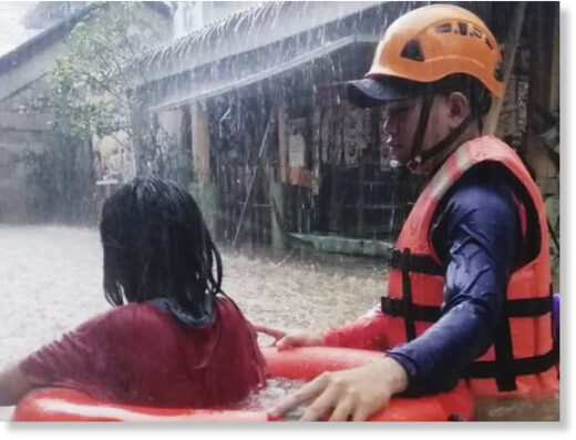 Rescuer assists a girl as they wade through flooding caused by Typhoon Rai in Cagayan de Oro City, southern Philippines on Thursday, December 16, 2021