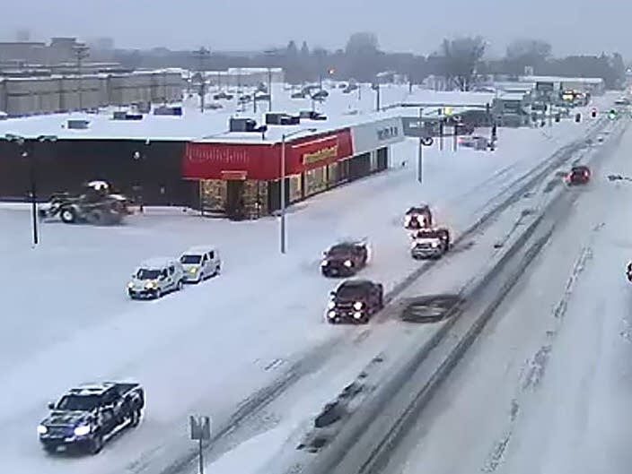 Traffic moves along a snow-covered State Highway 210 in Brainerd on Monday.
