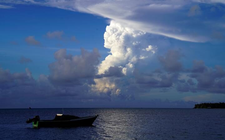 This picture taken on December 21, 2021 shows white gaseous clouds rising from the Hunga Ha'apai eruption seen from the Patangata coastline near Tongan capital Nuku'alofa.