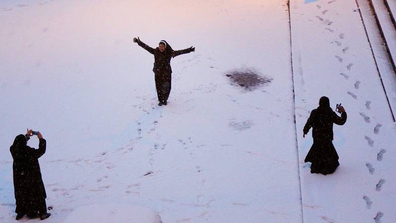 Women play in the snow.