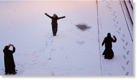 Women play in the snow.