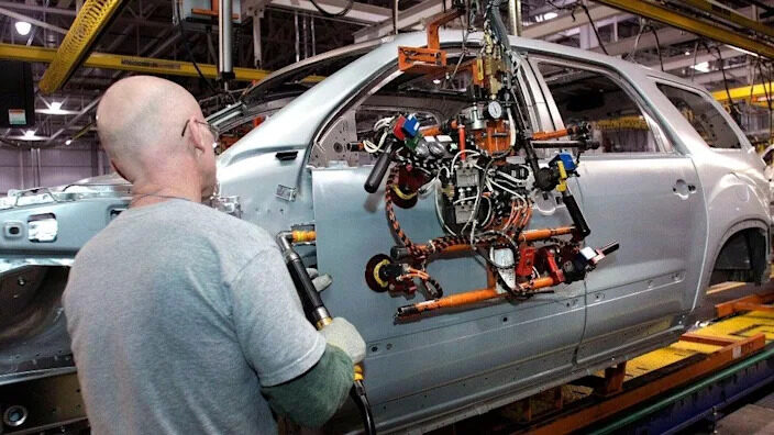 Click to enlarge A worker at a GM factory
