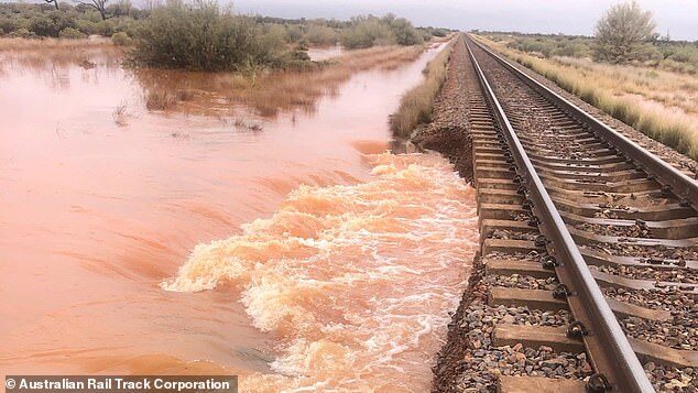 The supply chain chaos was sparked by a 'once in a lifetime' desert storm this week which flooded the transcontinental freight line (pictured) linking the NT and South Australia