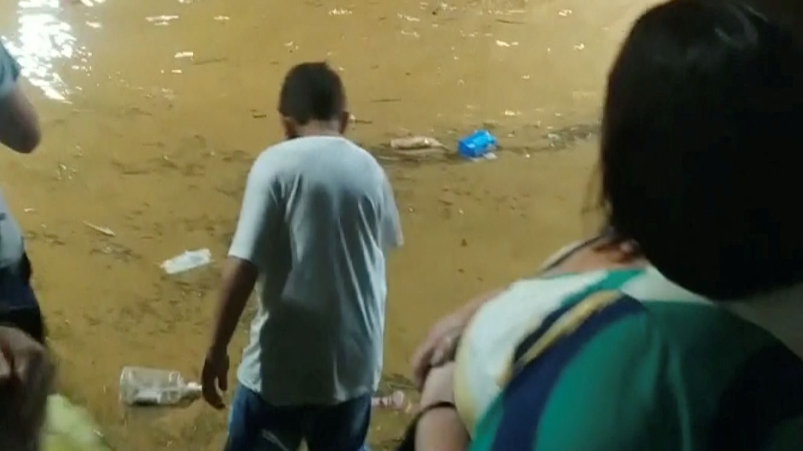 People stand among flooded streets in Petropolis.