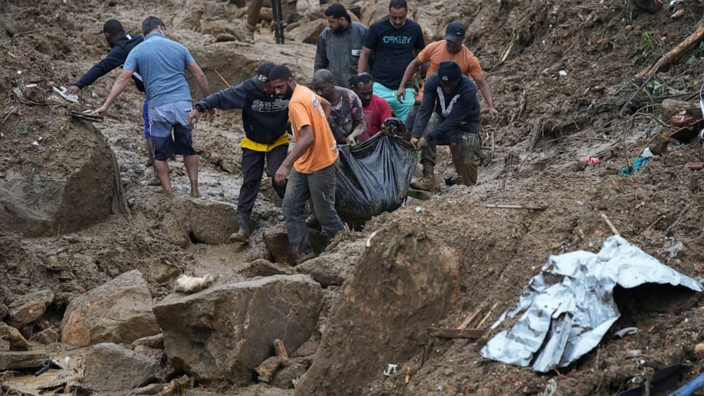 Residents and volunteers remove the body of a landslide victim in Petropolis, Brazil, Wednesday, Feb. 16, 2022.