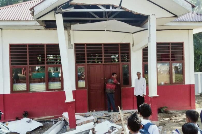 Residents inspecting a damaged building after a 6.2-magnitude earthquake, in Kajai village in West Pasaman, Sumatra, on Feb 25, 2022.