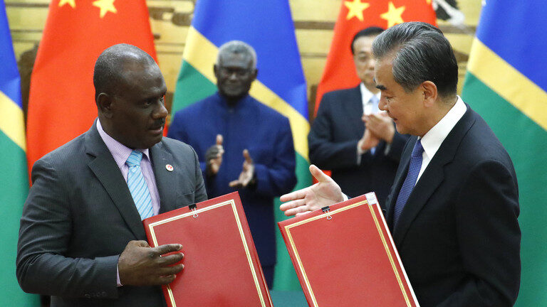 Click to enlarge Chinese State Councillor and Foreign Minister Wang Yi (R) and Solomon Islands