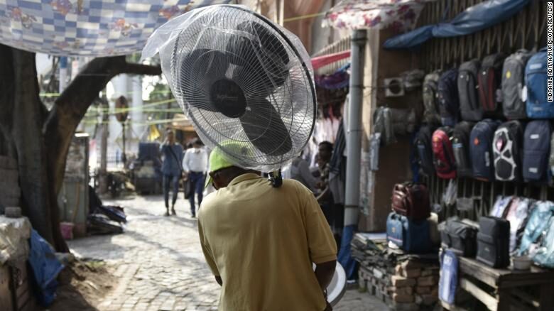 Click to enlarge A man carries a fan during a heat wave in Kolkata, India.