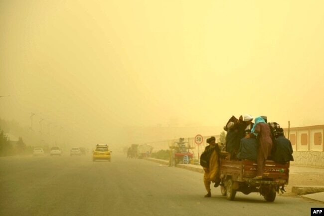 Commuters travel in a vehicle during a dust storm in Kandahar, Afghanistan.