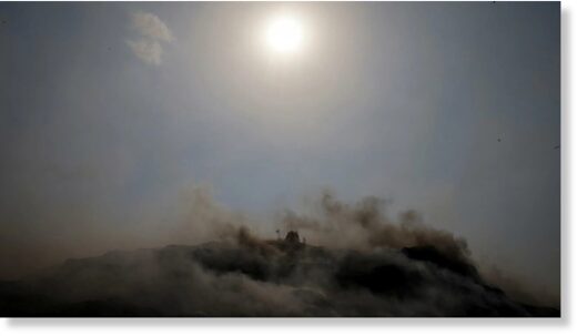 Click to enlarge An excavator tries to contain the fire as smoke billows from burning garbage on a hot summer day, at the Bhalswa landfill site in New Delhi, India, April 29, 2022.