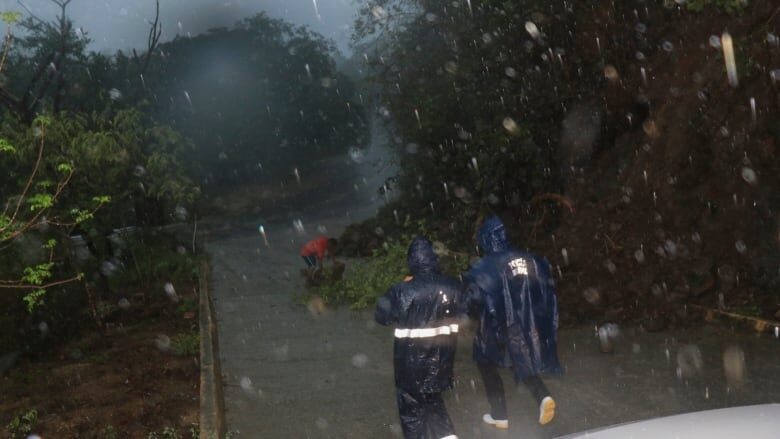 Municipal police officers patrol as rain falls during the arrival of Hurricane Agatha in Huatulco, Oaxaca state, on Monday night.