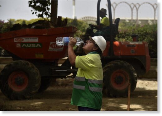 A construction worker drinks water to fight the scorching heat during a heatwave in Seville on June 13, 2022.
